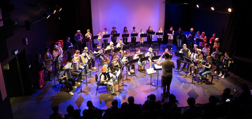 une assemblée de musiciens qui joue devant un public