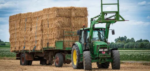 un tracteur et une remorque pleine de bottes de paille